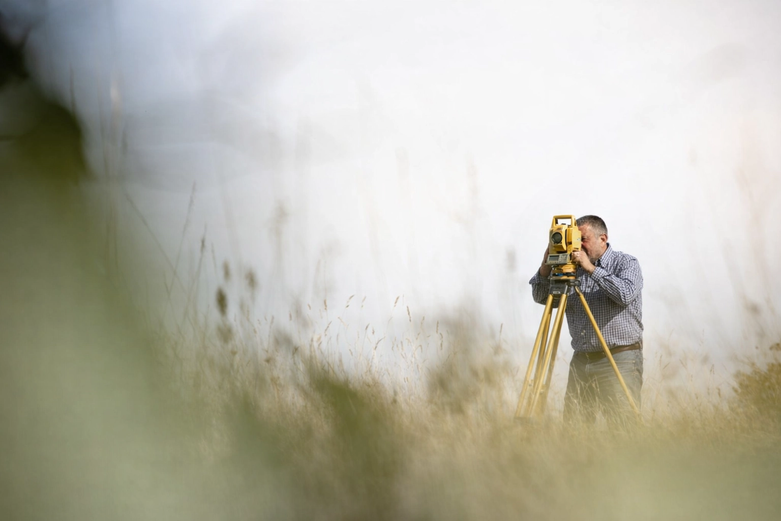 Geodetski stručnjak s preciznim mjernim instrumentom obavlja geodetsku izmjeru zemljišta na parceli u Istri